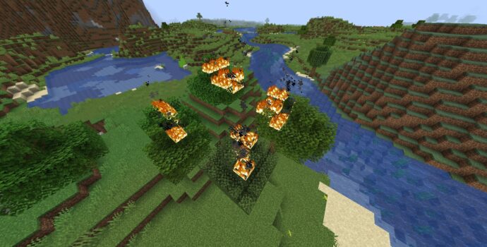 Screenshot of fire in Minecraft. A heavily stylized, pixelated block rendering of an outdoors environment with a river and several hills and cliffs. A cluster of trees in the center of the view is caught on fire.